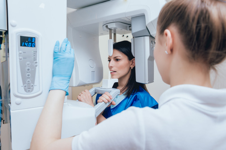 Young woman patient standing in x-ray machine. Panoramic radiography